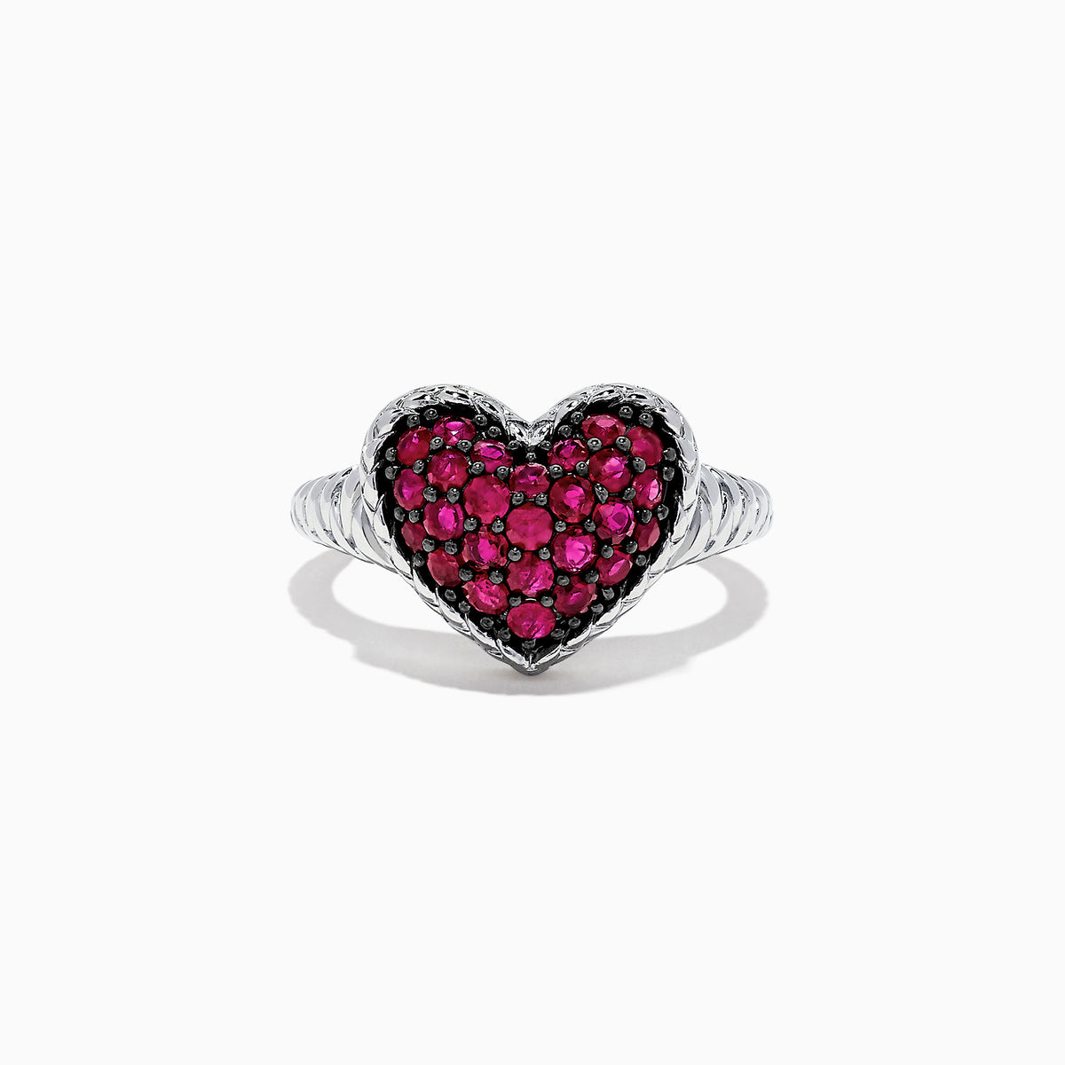 The 925 Sterling Silver Ruby Heart Ring, 1.02 TCW, showcases a heart-shaped centerpiece adorned with sparkling red stones set in silver against a white backdrop.