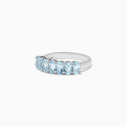 The Aquarius Sterling Silver Aquamarine Ring, 1.50 TCW, features a row of seven elongated oval light blue gemstones and is showcased on a plain white background.