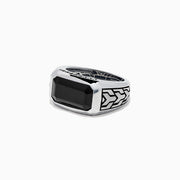 The Mens 925 Sterling Silver Onyx Ring, 4.38 TCW, features a large rectangular black onyx center with engraved geometric side patterns, displayed on a white background—a bold statement in mens jewelry.