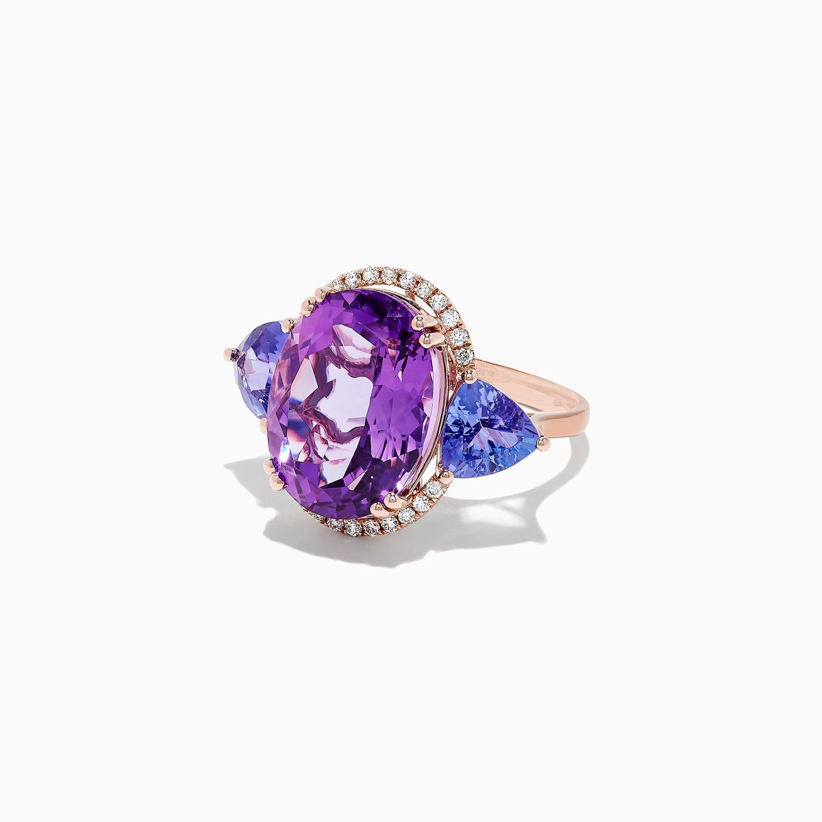 The 14K Rose Gold Amethyst, Tanzanite and Diamond Ring, 10.28 TCW features a striking amethyst center, accented by tanzanites and surrounded by a sparkling diamond halo.