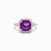 The 14K Rose Gold Amethyst and Diamond Ring showcases a large cushion-cut purple amethyst center, accented by small baguette and round diamonds, against a plain white background.