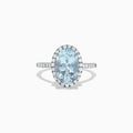 The Aquarius 14K White Gold Aquamarine and Diamond Ring, 3.45 TCW, showcases a large oval aquamarine center with a halo of sparkling round diamonds and additional diamonds along the sleek white gold band.