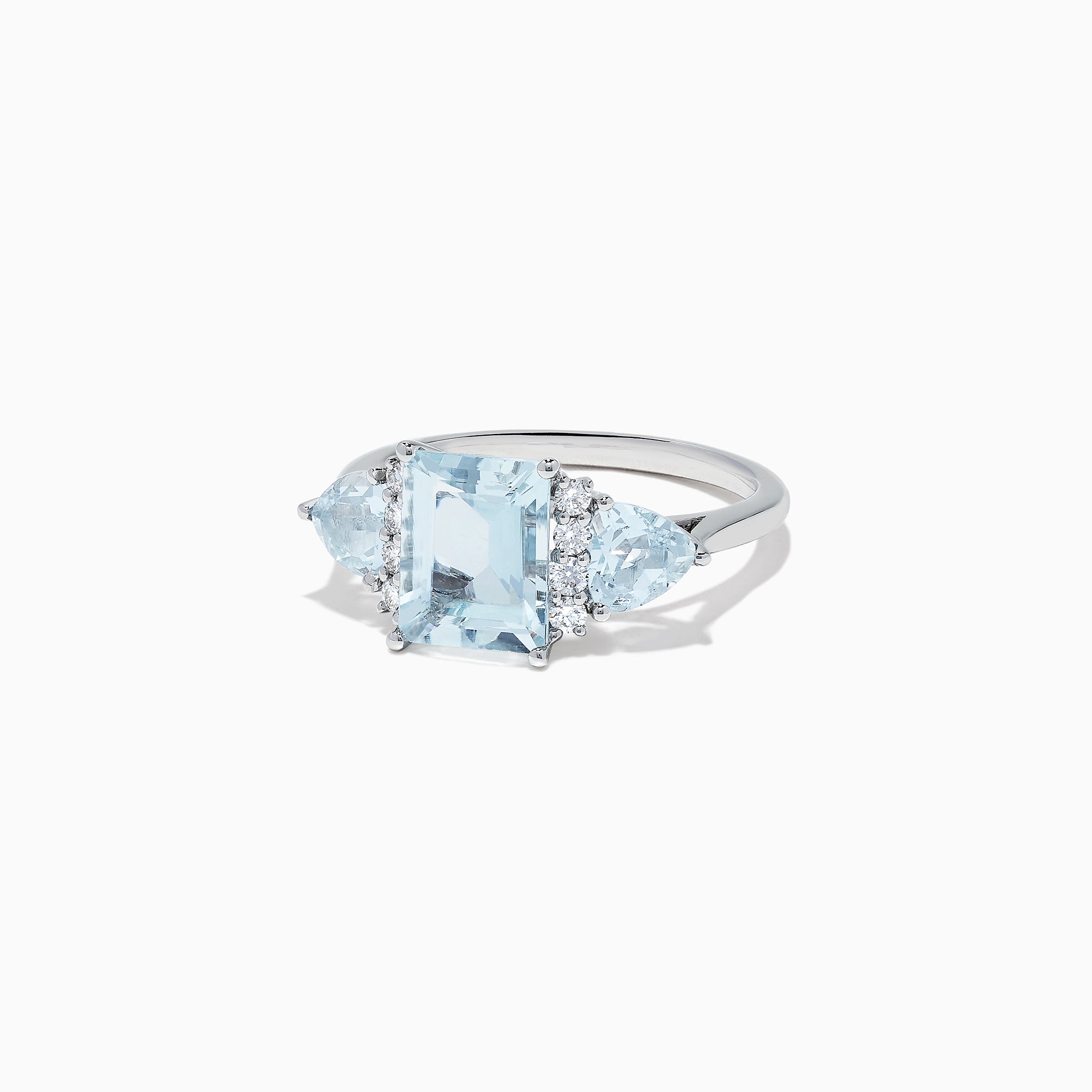 The Aquarius 14K White Gold Aquamarine and Diamond Ring, 3.30 TCW, showcases a large emerald-cut aquamarine center stone with two triangular blue side stones and sparkling round diamonds for added brilliance.