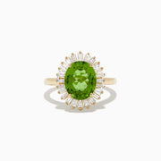 The 14K Yellow Gold Peridot and Diamond Ring features an oval peridot at the center, surrounded by a halo of baguette-cut diamonds, shown on a white background.