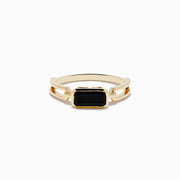 The 14K Yellow Gold Onyx Ring features a rectangular black onyx gemstone in the center, set on a polished yellow gold band with geometric side details.