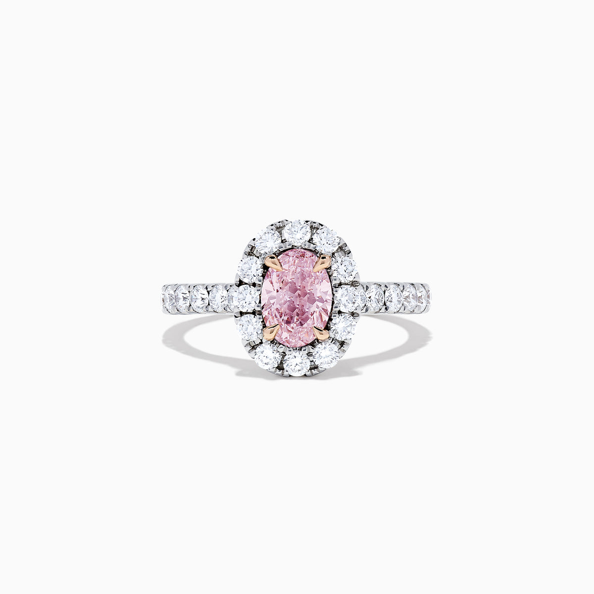 A GIA certified faint pink diamond ring, 1.53 TCW, set in a halo of round white diamonds on an 18K two tone gold band. Shown on a plain white background.