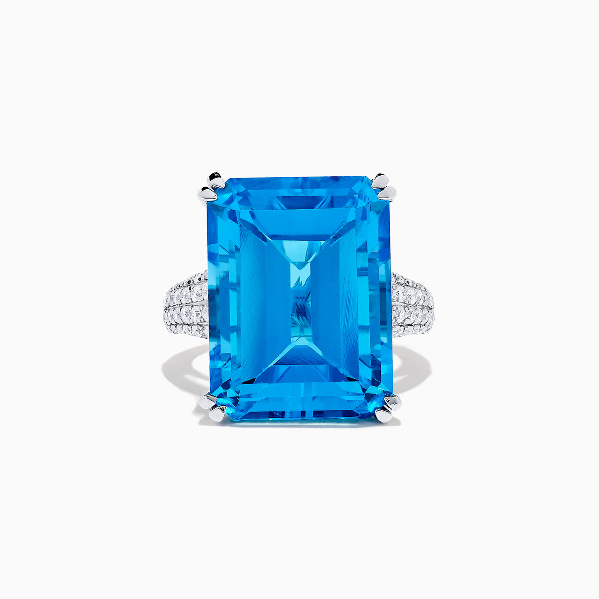 The 14K White Gold Blue Topaz and Diamond Ring, 29.29 TCW, features a large rectangular emerald-cut blue topaz accented by small white diamonds, shown on a white background.