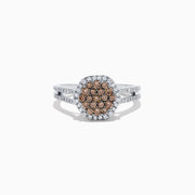 This 14K White Gold Espresso and White Diamond Ring features a split shank and a 1.50 TCW cluster of round brown diamonds at the center, surrounded by a halo of sparkling white diamonds.