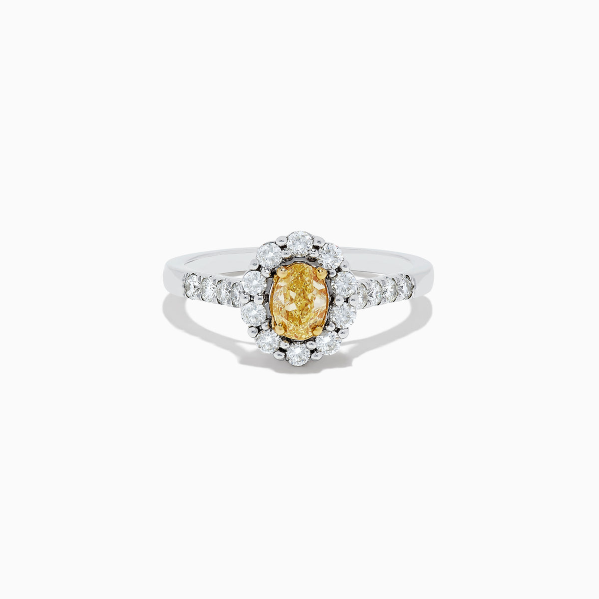 The 14K White Gold White and Fancy Yellow Diamond Ring, 1.10 TCW, features an oval yellow diamond center, haloed by clear round diamonds with more diamonds along the band—a timelessly elegant piece.