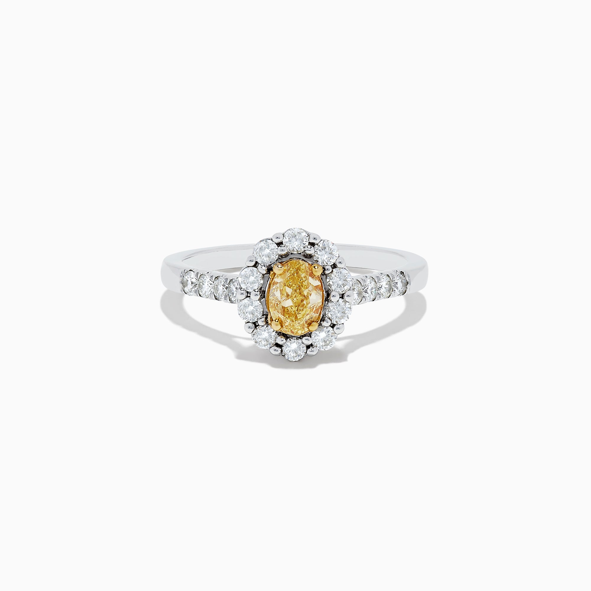 The 14K White Gold White and Fancy Yellow Diamond Ring, 1.10 TCW, features an oval yellow diamond center, haloed by clear round diamonds with more diamonds along the band—a timelessly elegant piece.