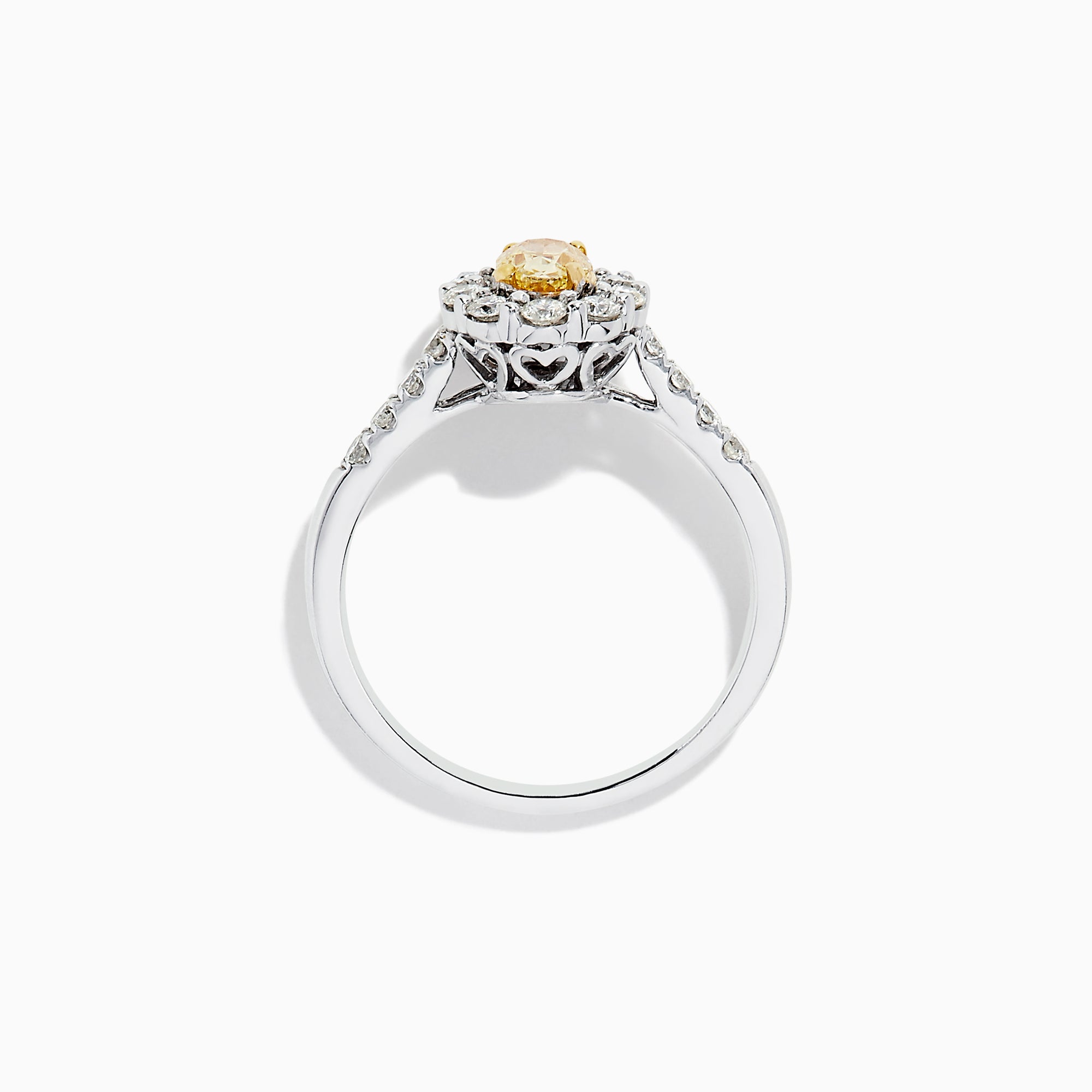 The 14K White Gold White and Fancy Yellow Diamond Ring, 1.10 TCW, features an oval yellow diamond center, haloed by clear round diamonds with more diamonds along the band—a timelessly elegant piece.