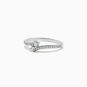 The 14k White Gold Diamond ring, 0.24 TCW, features a central round diamond on a curved band with sparkling accents and is displayed against a plain white background.