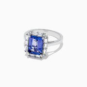 The Nahla Siri 14K White Gold Tanzanite and Diamond Ring, 5.03 TCW, features a large rectangular blue tanzanite center stone surrounded by a halo of baguette and round diamonds in an elegant, intricate design.