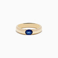 The Mens 14K Yellow Gold Blue Sapphire Ring features a flat band with a round, deep blue sapphire centerpiece, displayed on a plain white background.