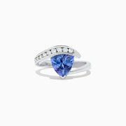 The Nahla Siri 14K White Gold Tanzanite and Diamond Ring, 1.88 TCW, showcases a large triangular blue tanzanite center with a curved band of round diamonds above it, set in an elegant modern design.