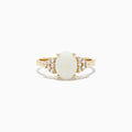 The 14K Yellow Gold Opal and Diamond Ring, 1.13 TCW features an oval white opal center accented by clusters of round diamonds on each side, all set in yellow gold against a white background.