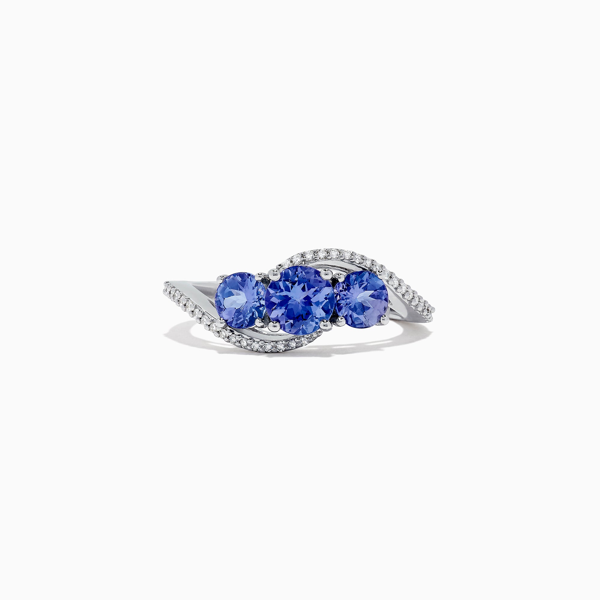The Nahla Siri 14K White Gold Tanzanite and Diamond Ring, 1.63 TCW, showcases three round tanzanites at the center with curved rows of sparkling white diamonds on each side, all displayed against a white background.