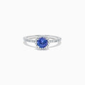 The Nahla Siri 14K White Gold Tanzanite and Diamond Ring, 1.08 TCW, features a round blue tanzanite encircled by a diamond halo with additional diamonds along the band for extra sparkle.