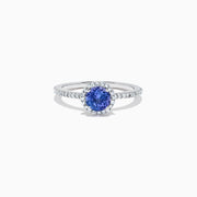 The Nahla Siri 14K White Gold Tanzanite and Diamond Ring, 1.08 TCW, features a round blue tanzanite encircled by a diamond halo with additional diamonds along the band for extra sparkle.