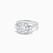 The Bouquet 14K White Gold Diamond Engagement Ring features a large round center diamond, a halo of sparkling stones, and diamonds along the band for added brilliance. Shown on a white background. Total carat weight: 1.91 TCW.