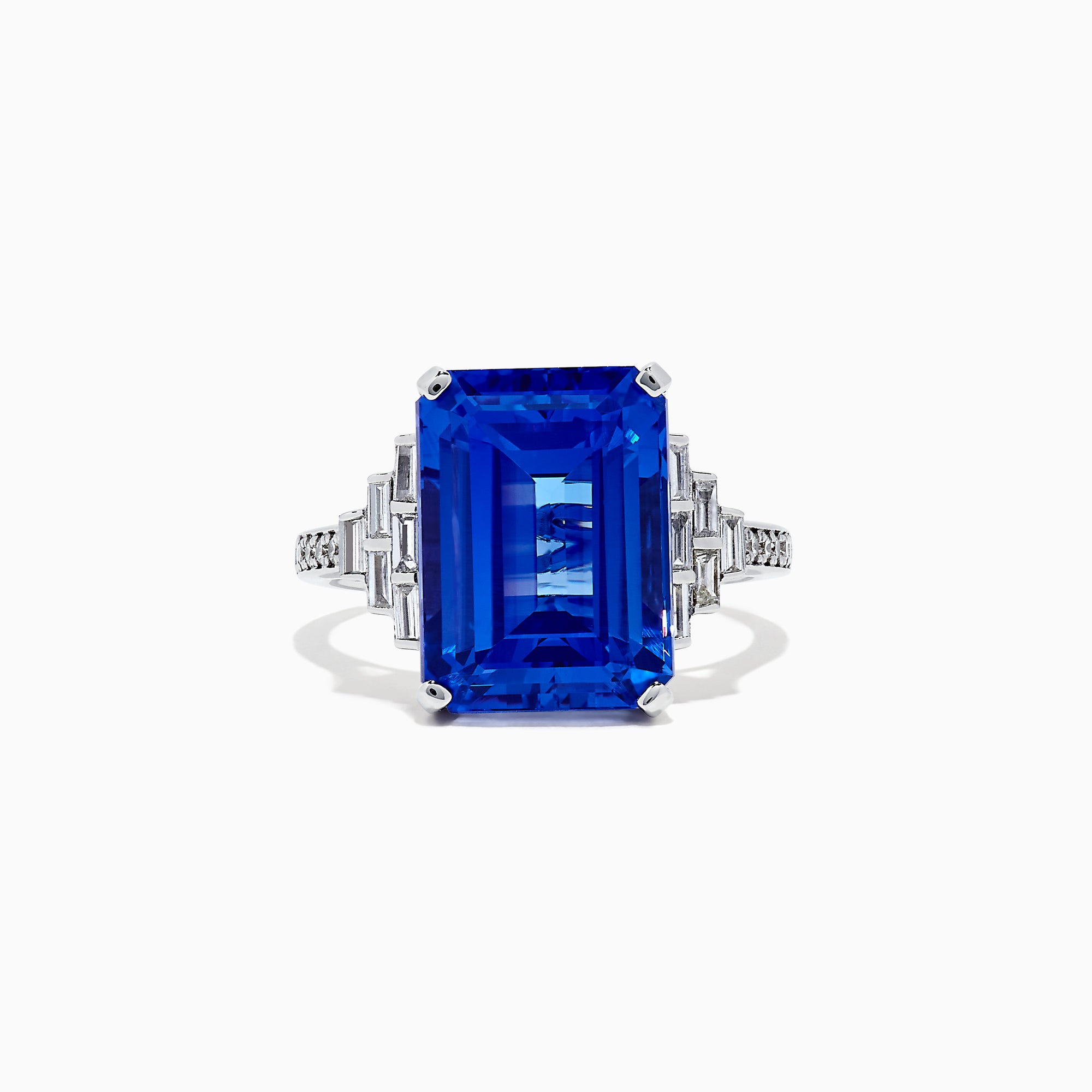 The 14K White Gold Tanzanite and Diamond Cocktail Ring, 7.83 TCW, features a large rectangular blue tanzanite with step-cut facets, accented by geometric clusters of sparkling diamonds on each side, showcased against a white background.