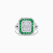 The Brasilica 14K White Gold Emerald and Diamond Ring showcases an emerald-cut diamond center, double square halos of diamonds and green emeralds, with additional diamonds on the split shank band, all set against a white background.