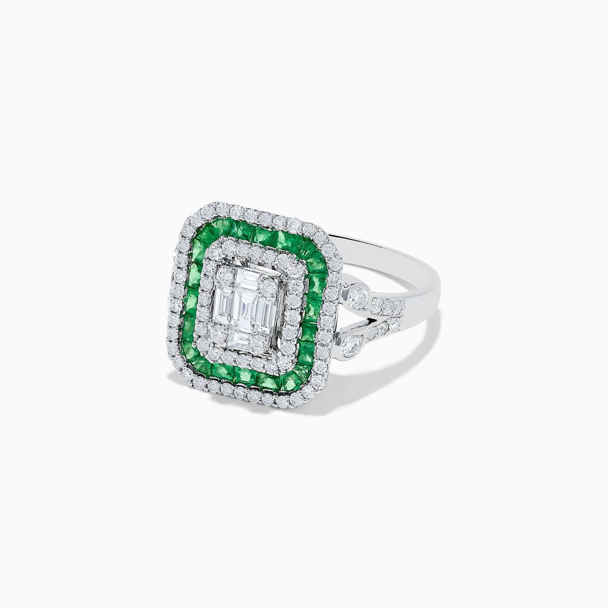 The Brasilica 14K White Gold Emerald and Diamond Ring showcases an emerald-cut diamond center, double square halos of diamonds and green emeralds, with additional diamonds on the split shank band, all set against a white background.