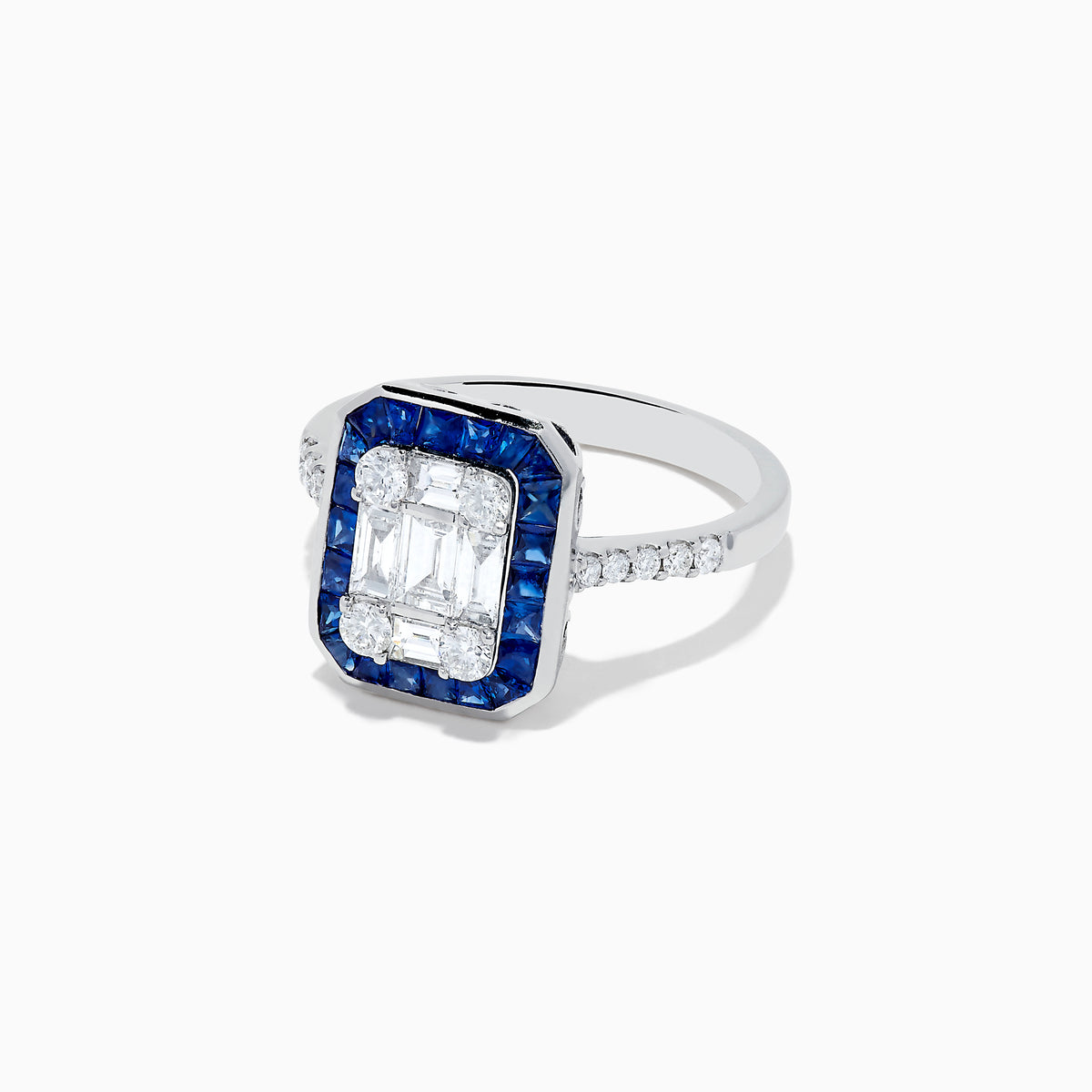 The Royale Bleu 14K White Gold Blue Sapphire and Diamond Deco Ring features a rectangular emerald-cut center, accented by blue sapphires and round diamonds along the band, all set against a white backdrop.