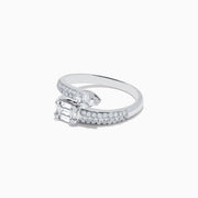 The Classique 14K White Gold Diamond Bypass Ring (0.65 TCW) features an emerald-cut center diamond accented by round diamonds along its split band, blending elegance and sparkle in a refined design.