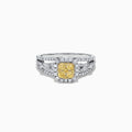 The Canare 14K Two Tone Gold Cushion Shaped Cluster Yellow Diamond Ring, 0.72 TCW, features a cushion-cut yellow stone surrounded by clear diamonds and additional diamonds set along the split band.