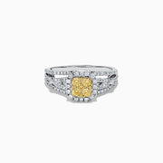 The Canare 14K Two Tone Gold Cushion Shaped Cluster Yellow Diamond Ring, 0.72 TCW, features a cushion-cut yellow stone surrounded by clear diamonds and additional diamonds set along the split band.
