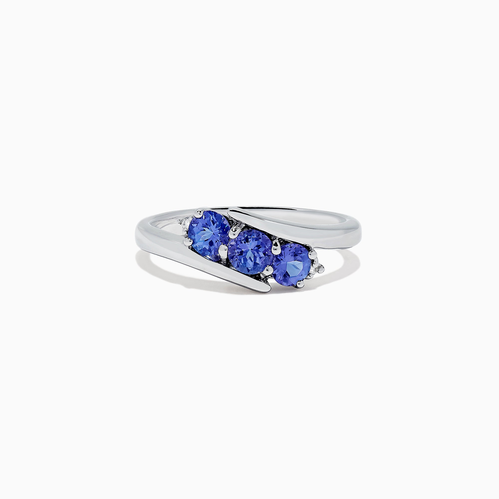 The Nahla Siri Sterling Silver Tanzanite and Diamond Ring (0.86 TCW) showcases three round tanzanites set side by side in a modern overlapping band, displayed on a white background.