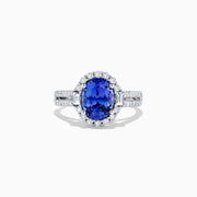 The 14K White Gold Tanzanite and Diamond Ring, 3.03 TCW, features an oval blue tanzanite center stone encircled by a halo of diamonds and additional diamonds set on the band.