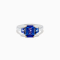 The Nahla Siri 14K Two-Tone Gold Tanzanite Ring showcases a large rectangular blue gemstone with two smaller triangular accents, all in a four-prong setting for a striking effect.
