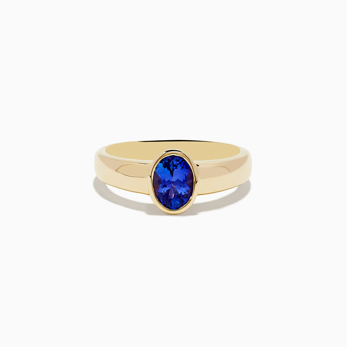 The Nahla Siri 14K Yellow Gold Tanzanite Ring features an oval-shaped deep blue gemstone in a simple bezel setting, shown against a white background.